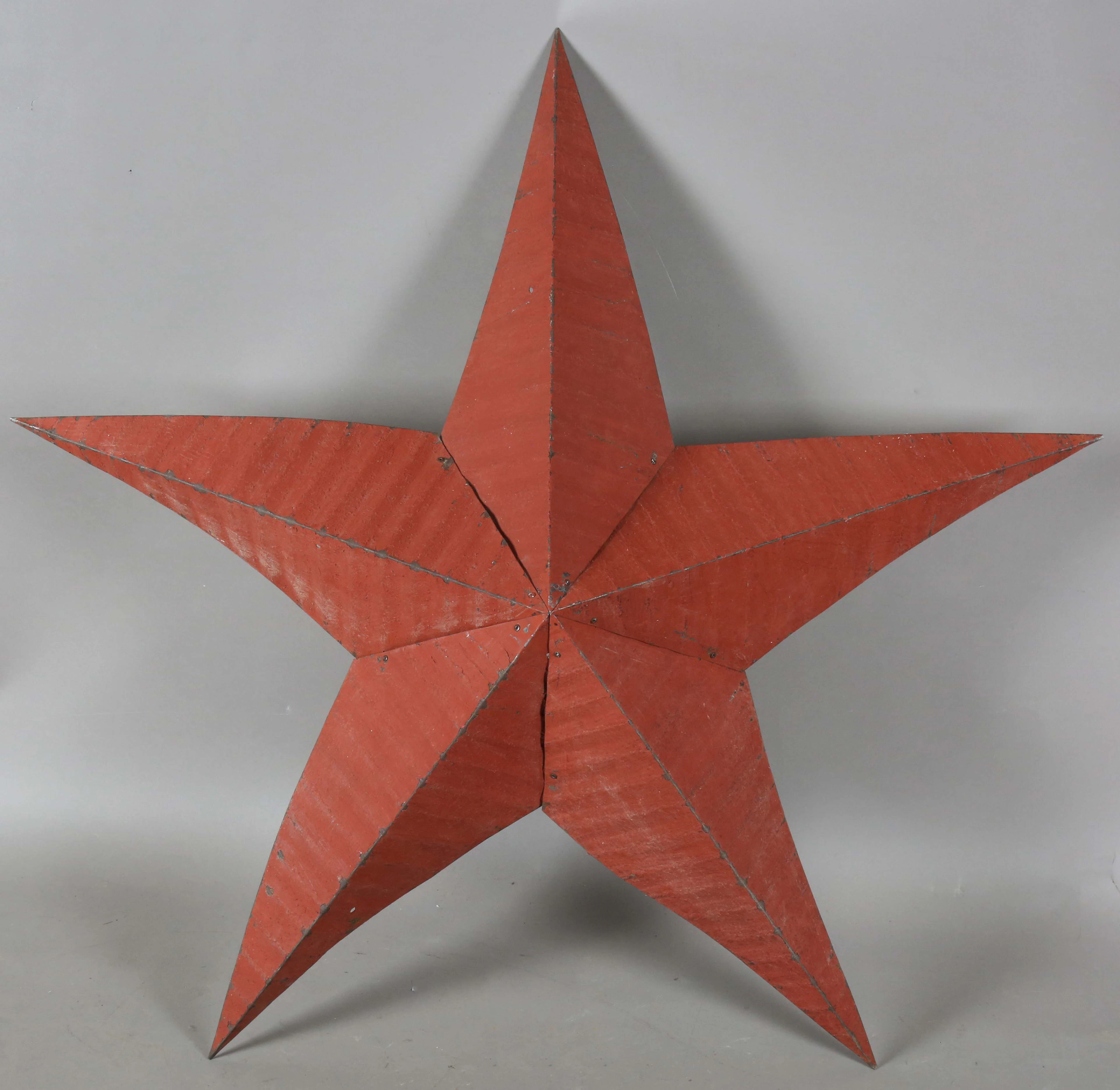 A late 20th century red tole painted tin five-pointed star wall appliqué