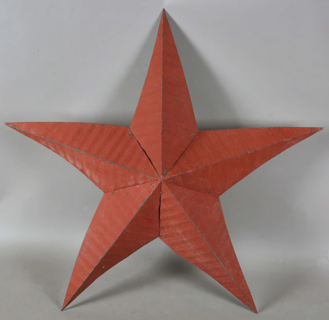 A late 20th century red tole painted tin five-pointed star wall appliqué
