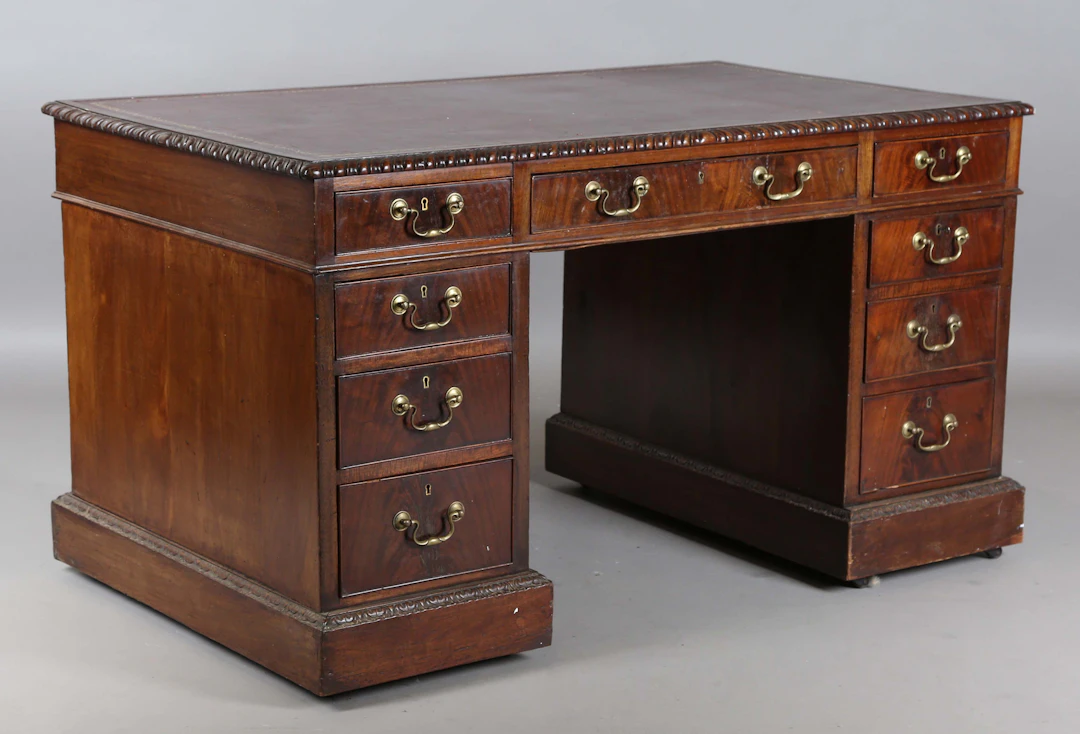 An early 20th century mahogany twin pedestal desk, the gadrooned top