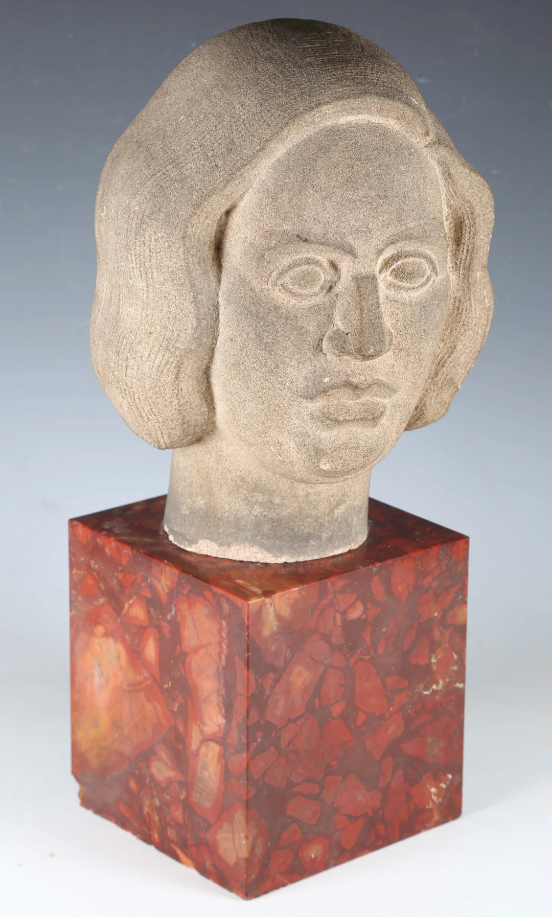 A mid-20th century carved stone stylized head of a woman, in the manner