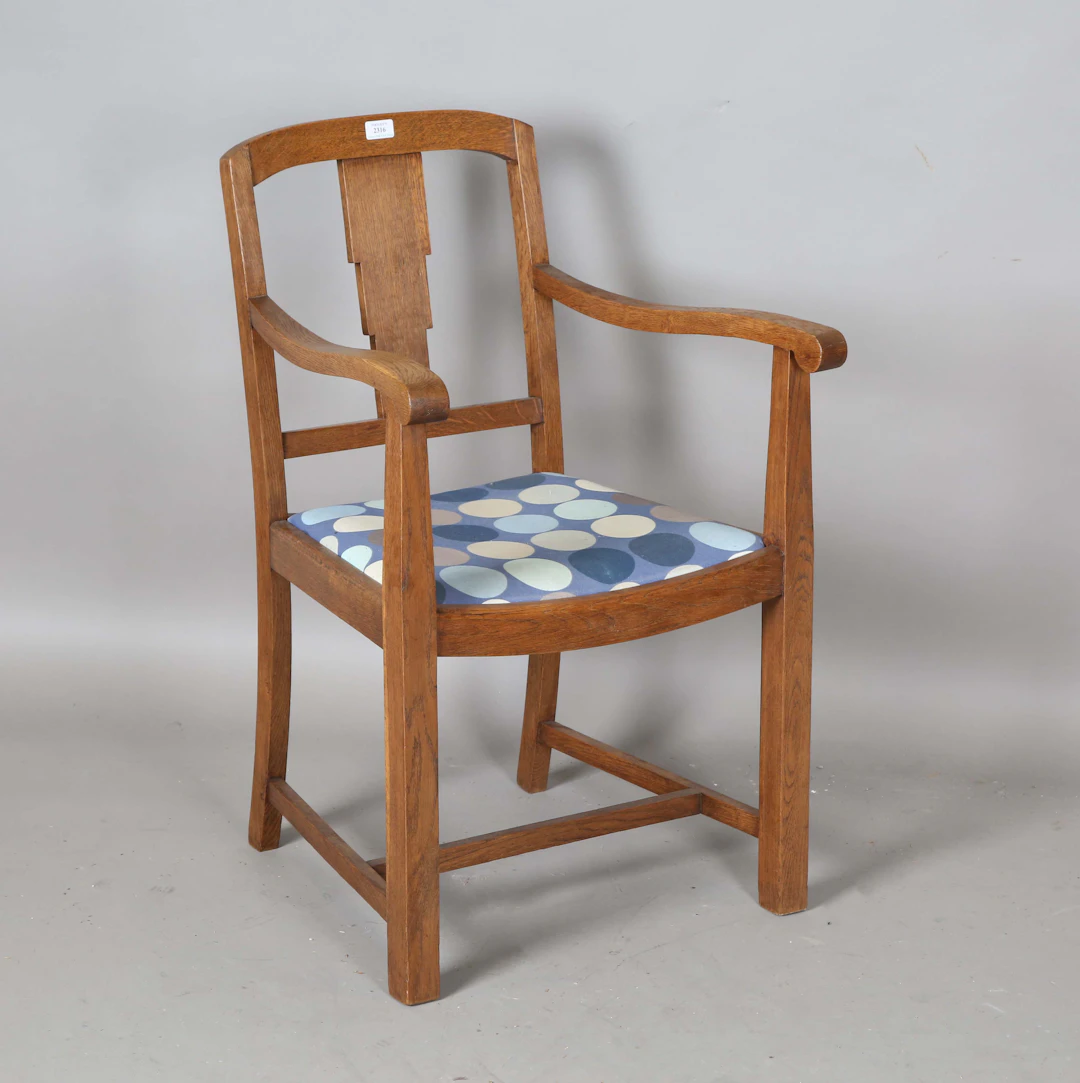 An early 20th century oak framed elbow chair, attributed to Heal &
