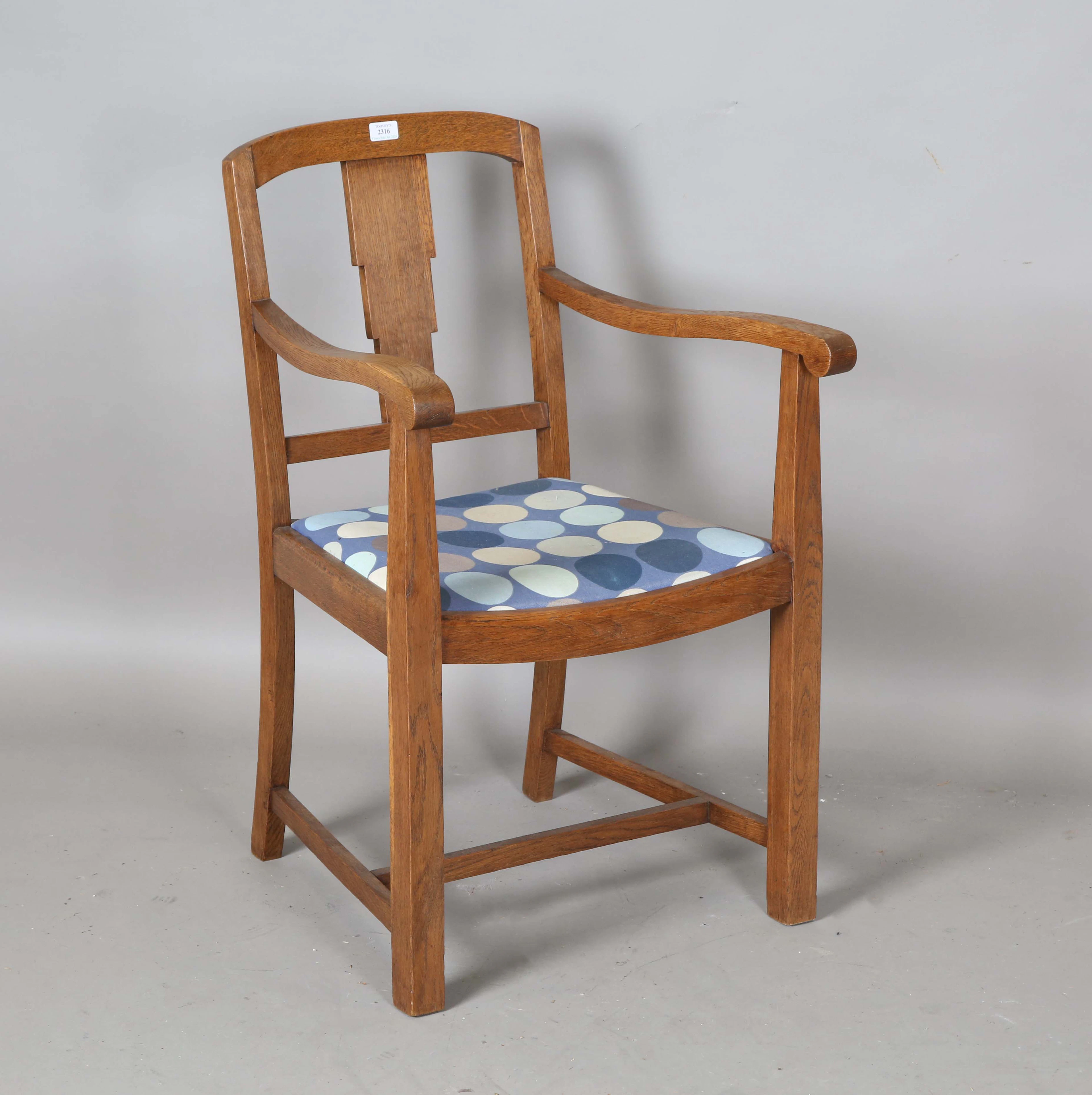 An early 20th century oak framed elbow chair, attributed to Heal &