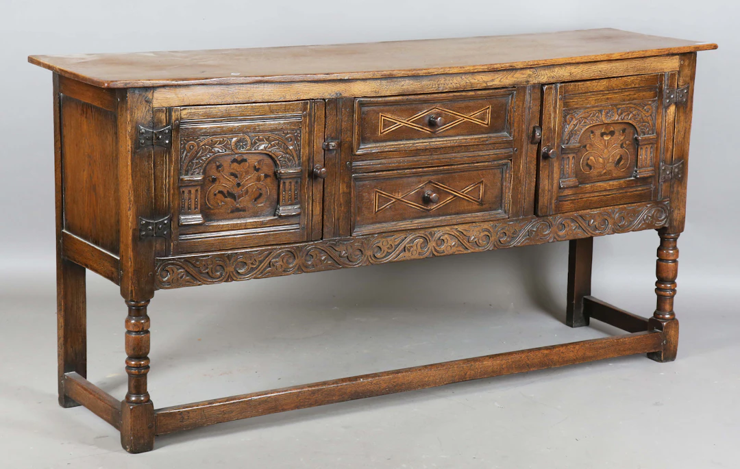 A mid-20th century Tudor Revival oak sideboard, the two central drawers