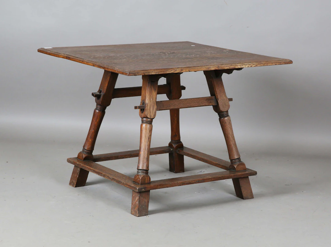 An early 20th century Arts and Crafts oak square centre table, the