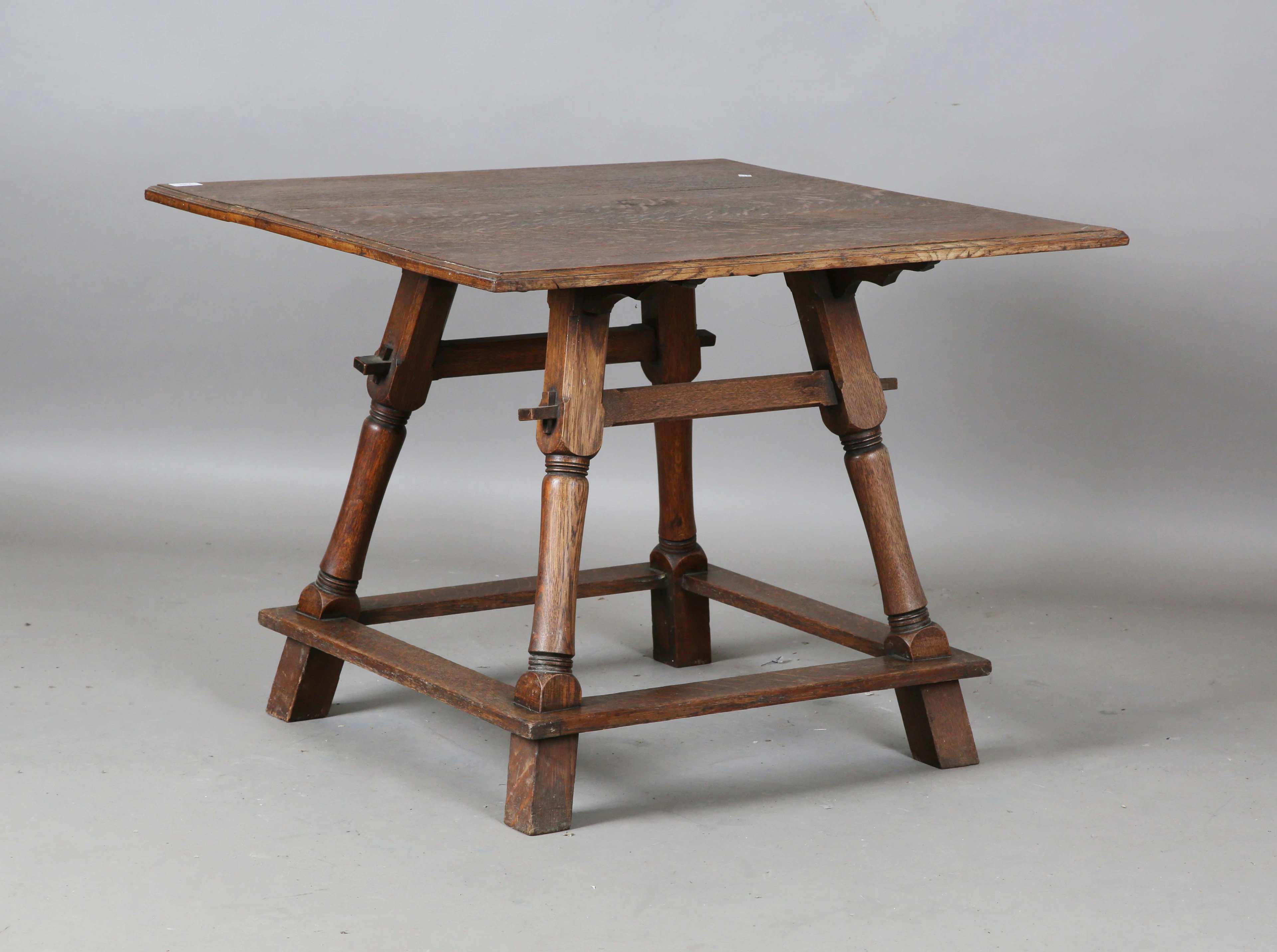 An early 20th century Arts and Crafts oak square centre table, the
