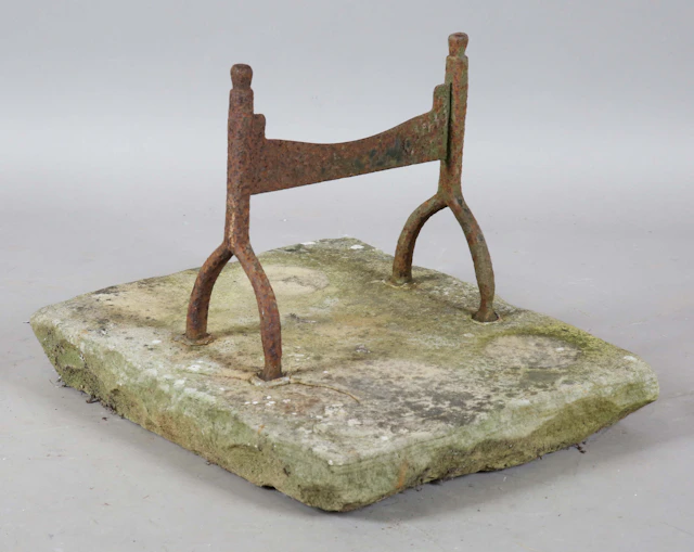 A 19th century wrought iron bootscraper, set in to a stone slab base
