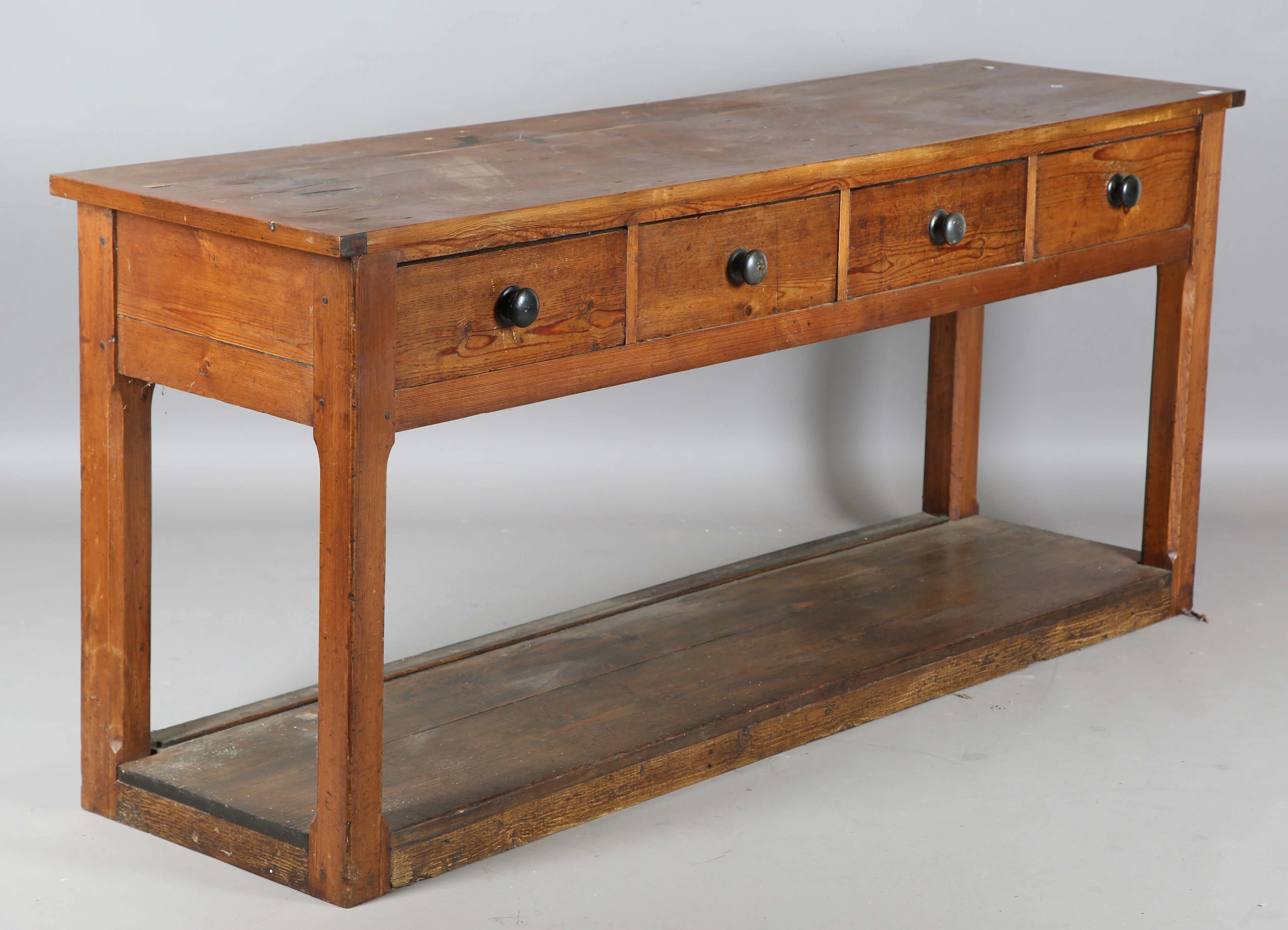 A 19th century pine four-drawer serving table, on block legs united