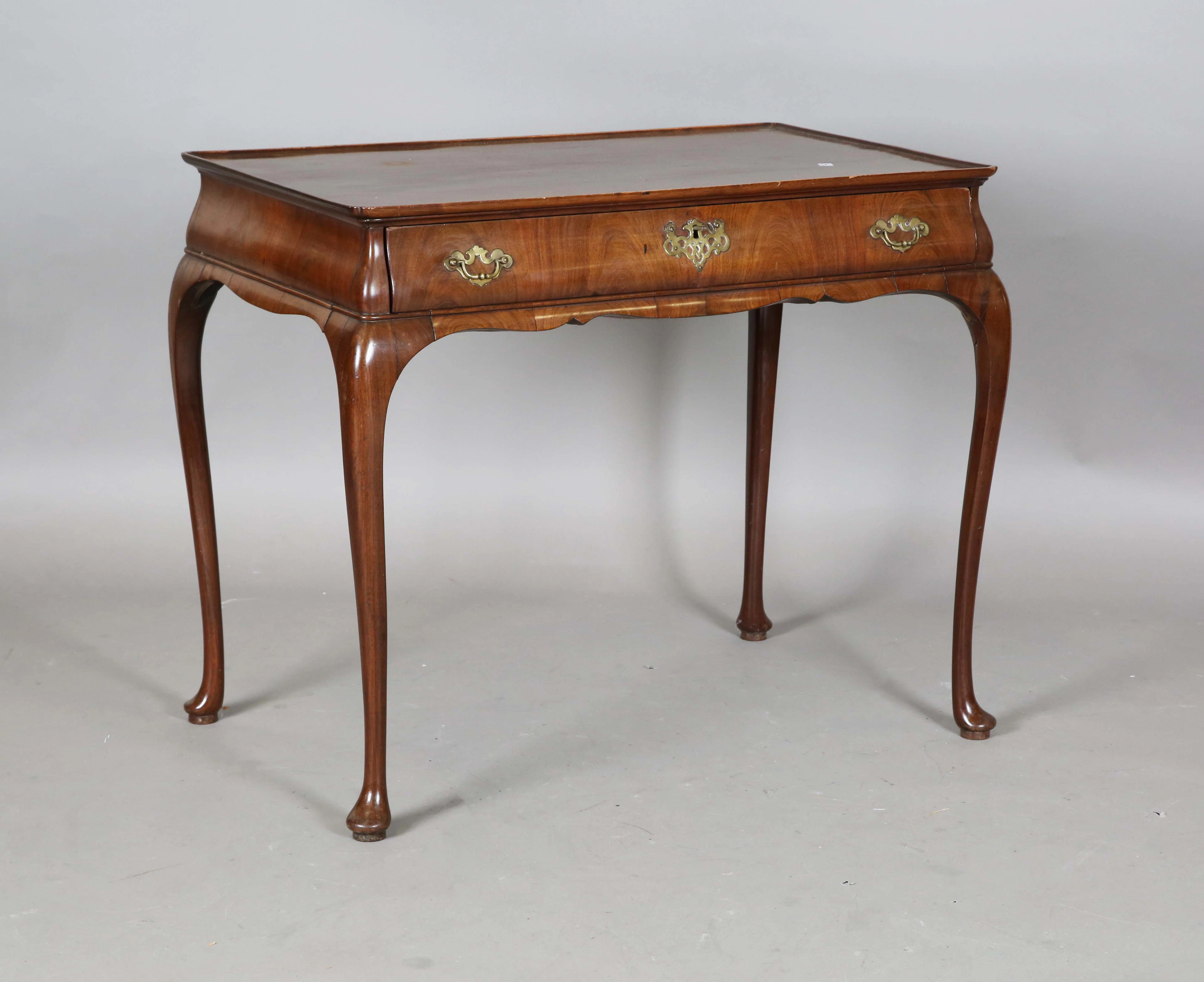 An early 18th century walnut silver table with single cushion frieze