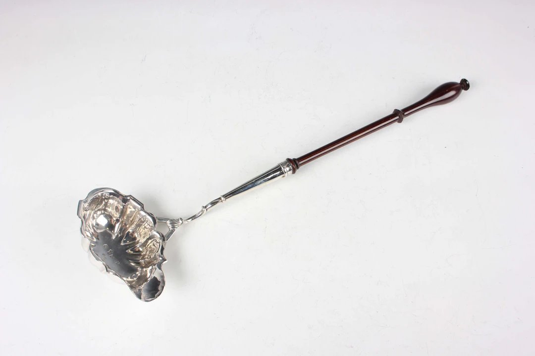 A George II silver punch ladle with fluted bowl and turned mahogany
