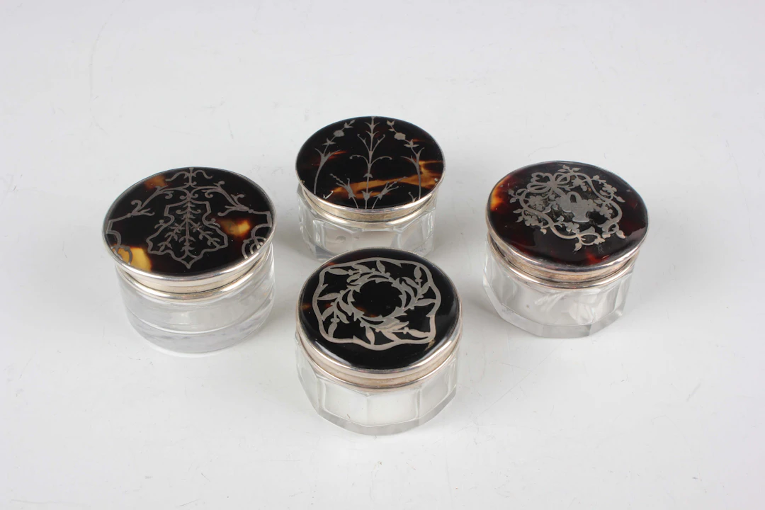 Four Edwardian and later silver and tortoiseshell lidded cut glass