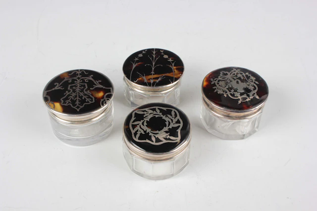 Four Edwardian and later silver and tortoiseshell lidded cut glass