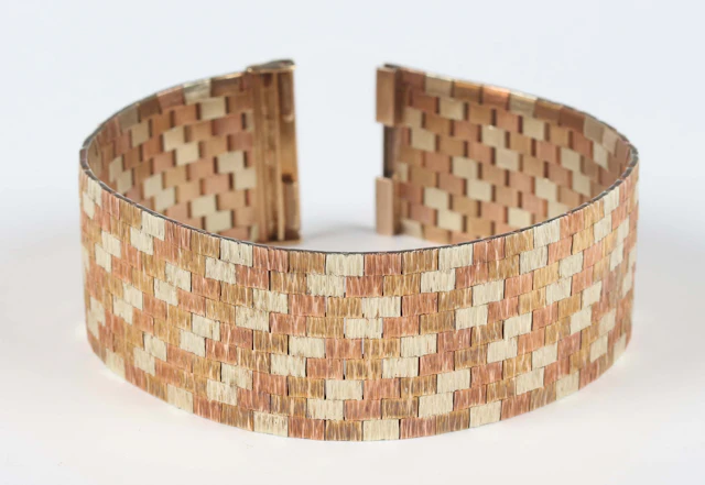 A 9ct three colour gold wide brick link bracelet, designed by Roy