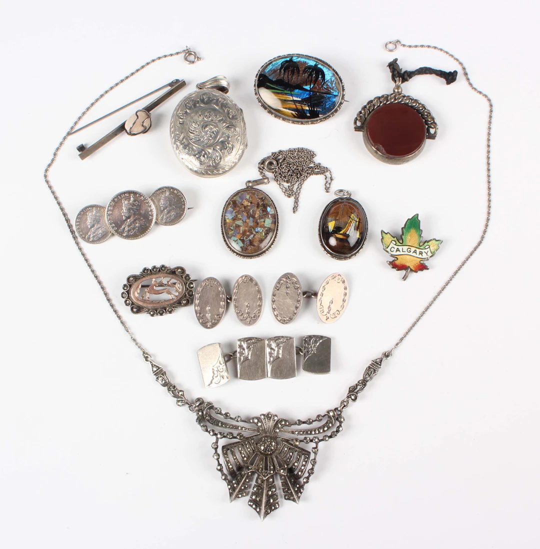 A group of mostly silver jewellery, comprising an oval pendant locket