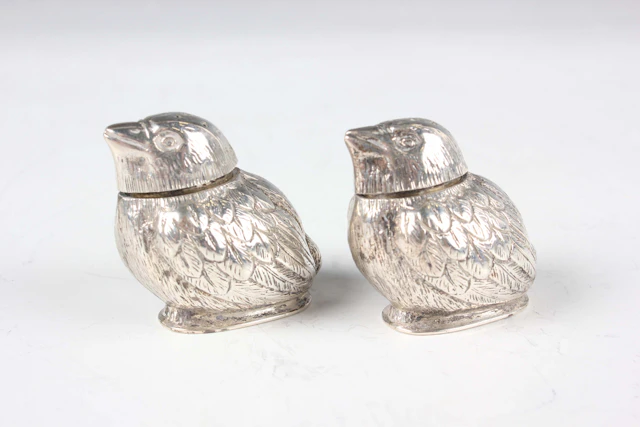 A pair of Edwardian silver novelty pepper casters, each in the form