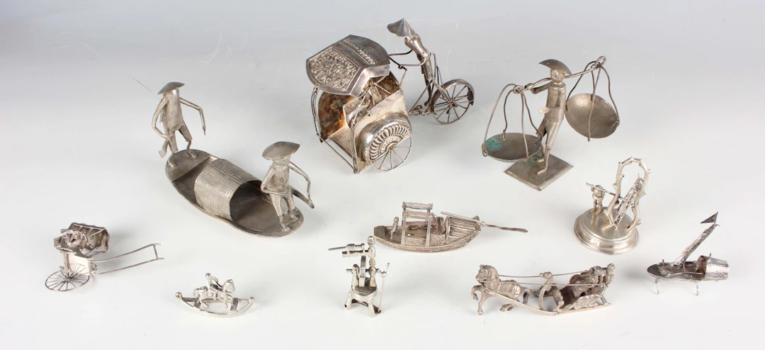 A small group of seven miniature toy silver items, including a 20th