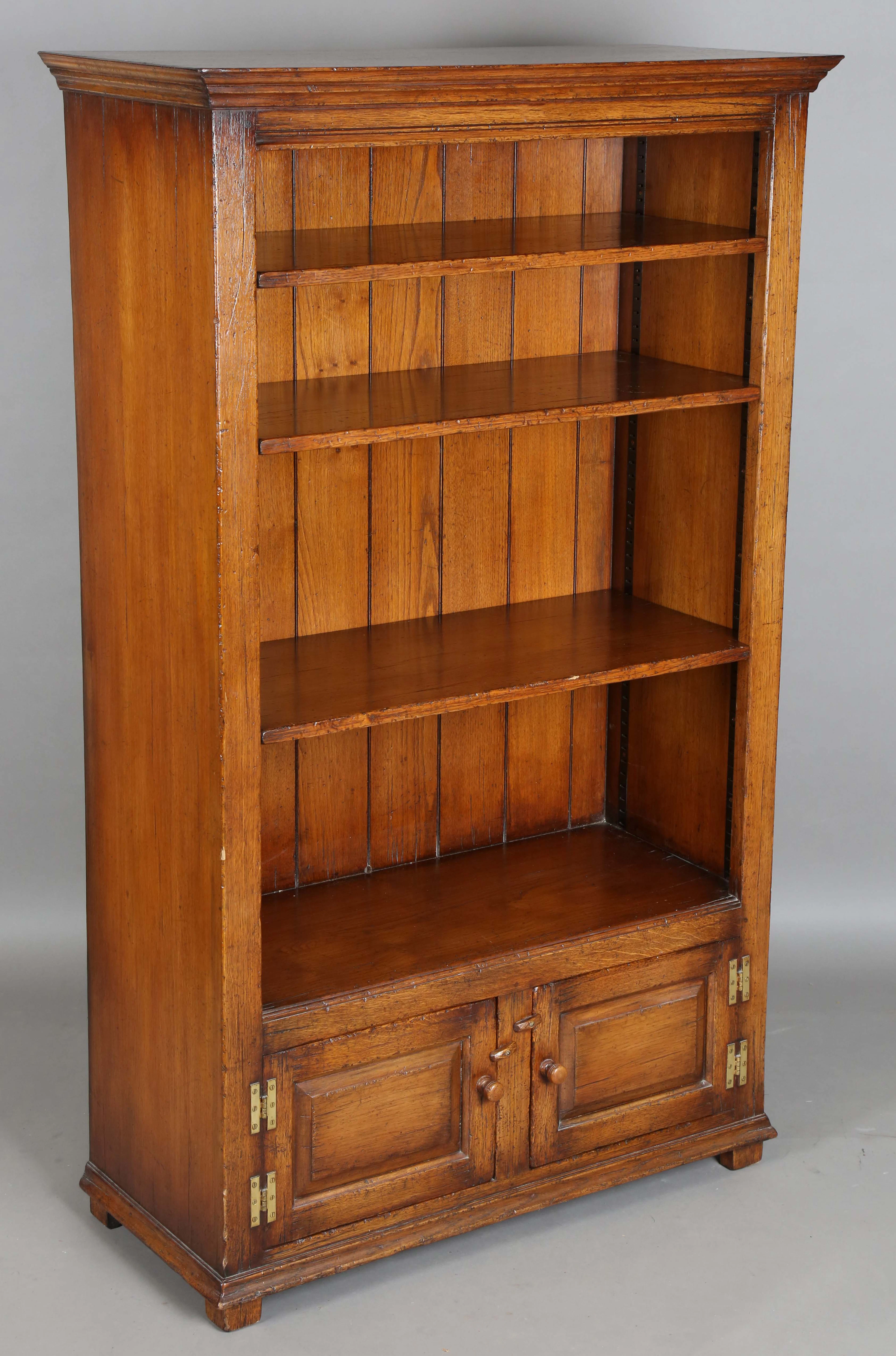 A late 20th century reproduction oak open bookcase, fitted with three