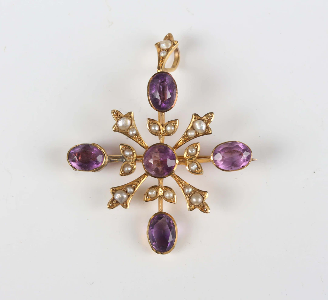 A gold, amethyst and seed pearl pendant brooch in a cruciform design