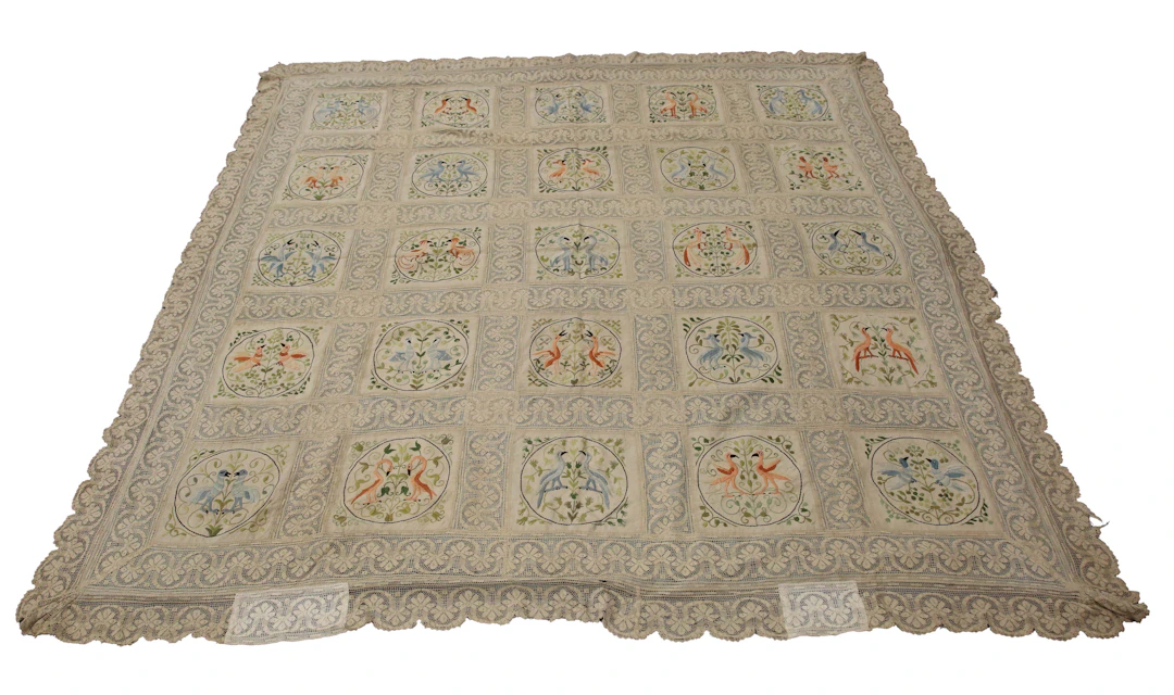 An early 20th century Arts and Crafts lace and silk embroidered bedcover
