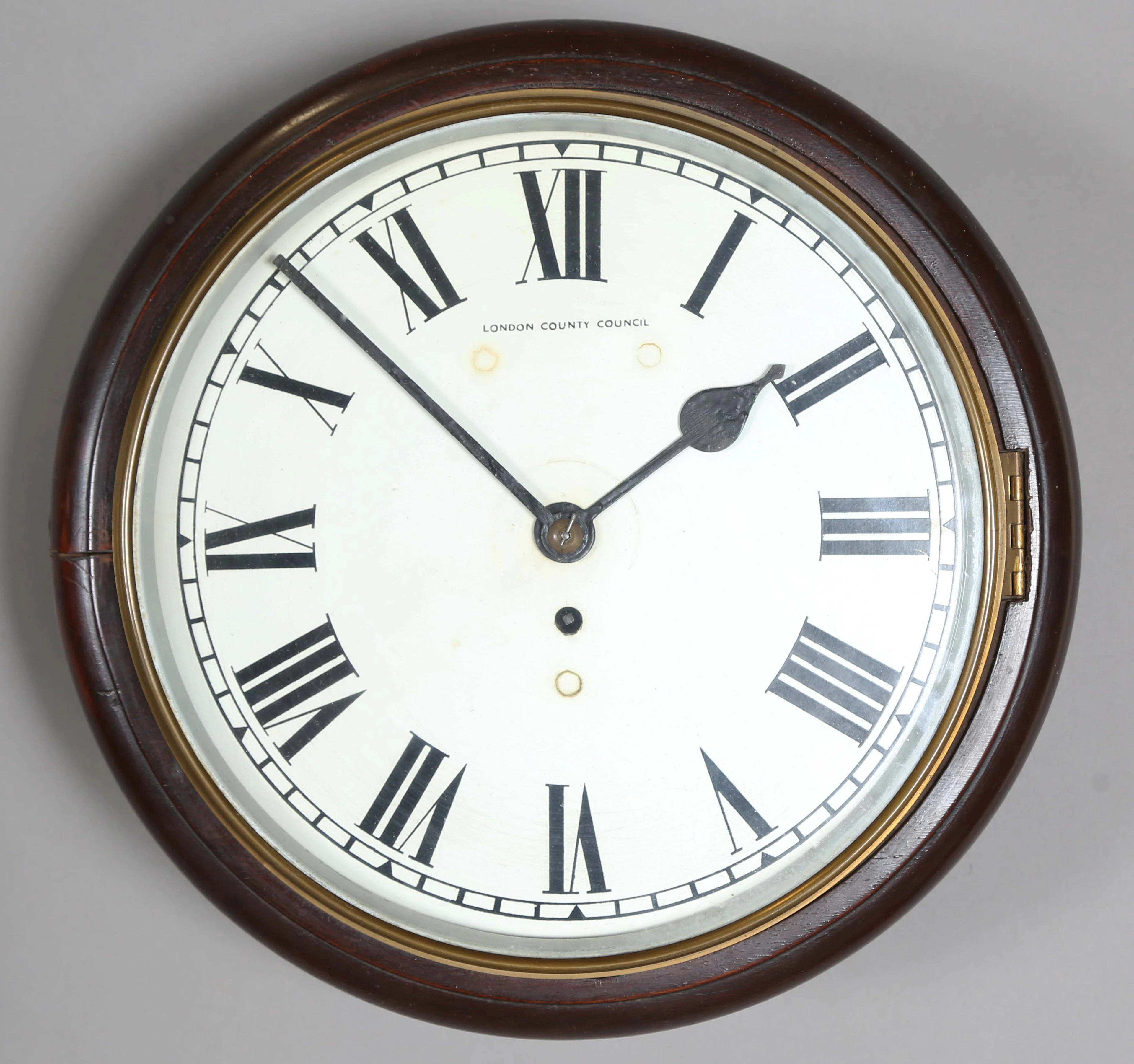 An early 20th century stained beech circular cased wall timepiece