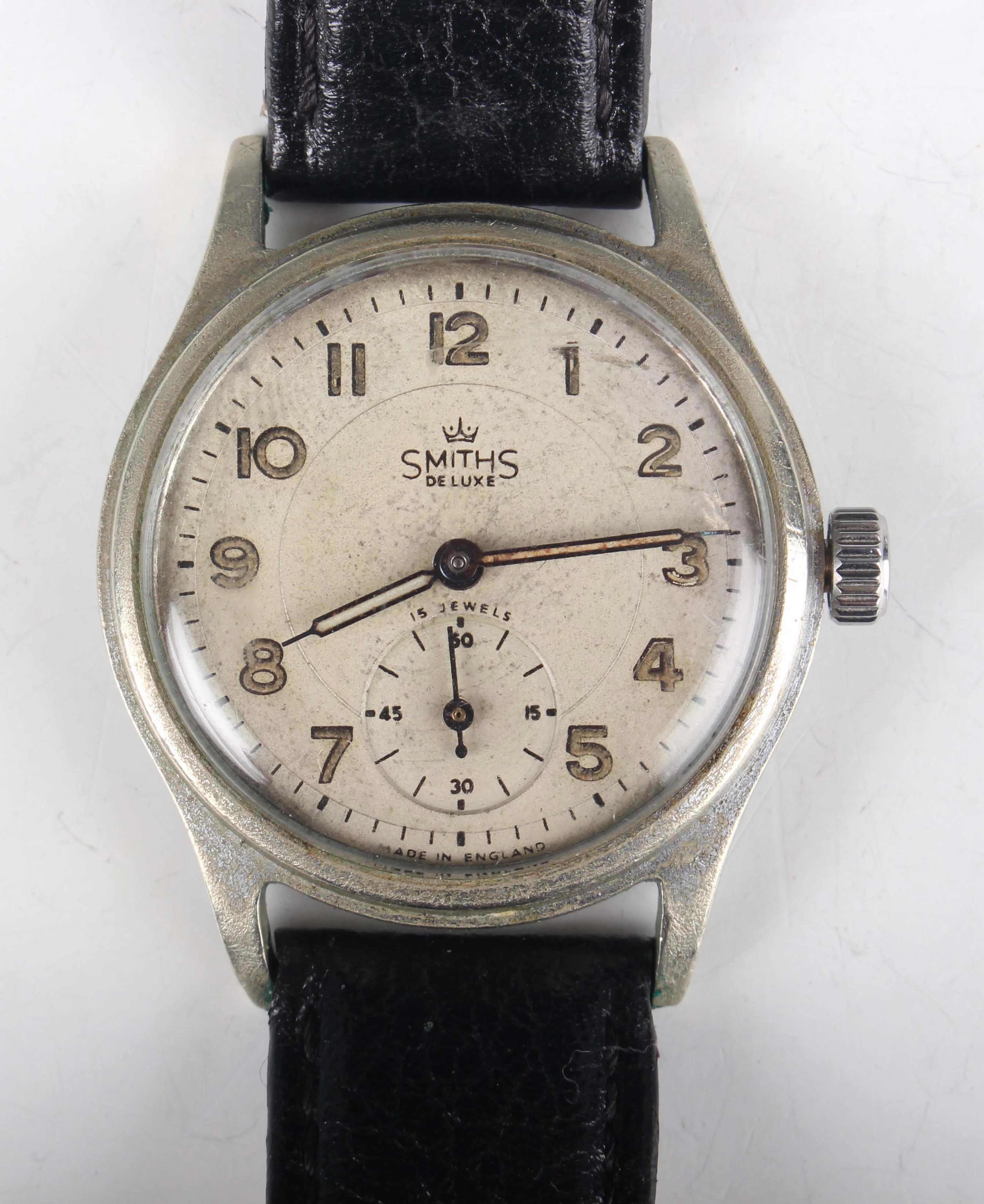 A Smiths De Luxe base metal fronted and steel backed circular cased