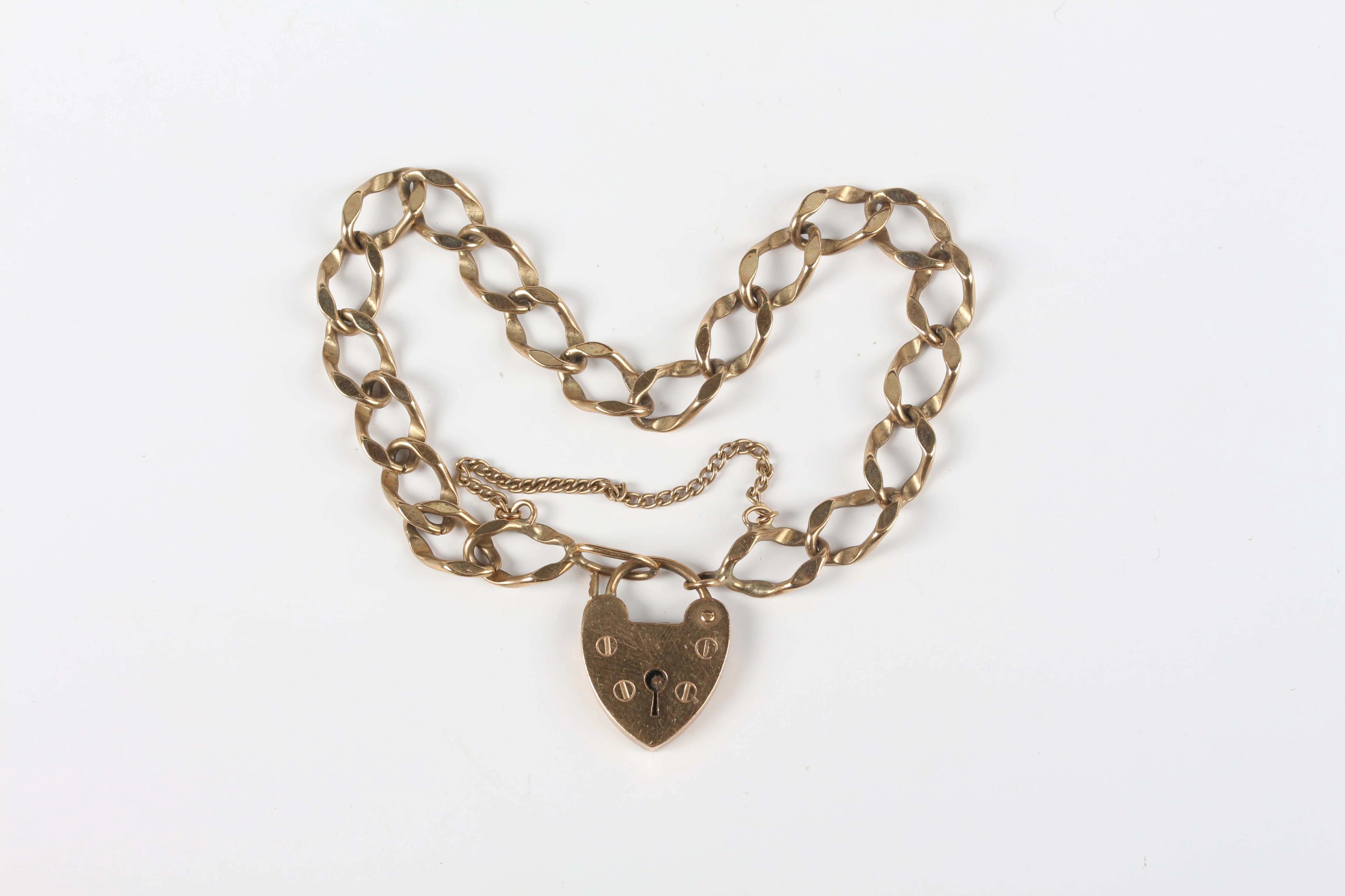 A gold faceted curblink bracelet on a heart shaped padlock clasp