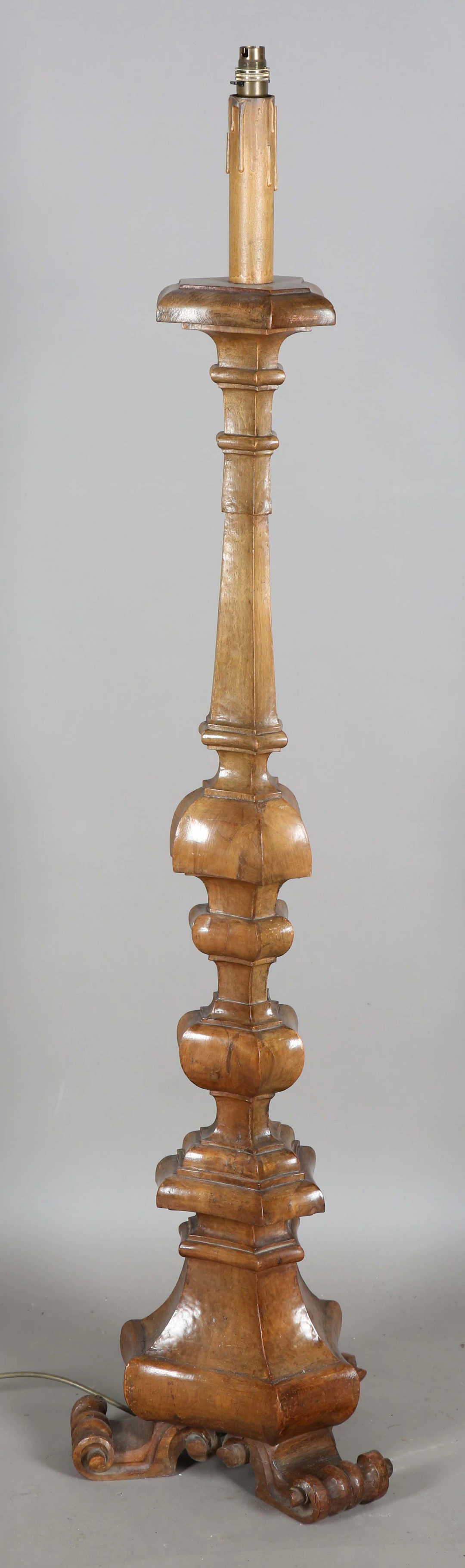 An early 20th century Continental carved walnut lamp standard of multiple
