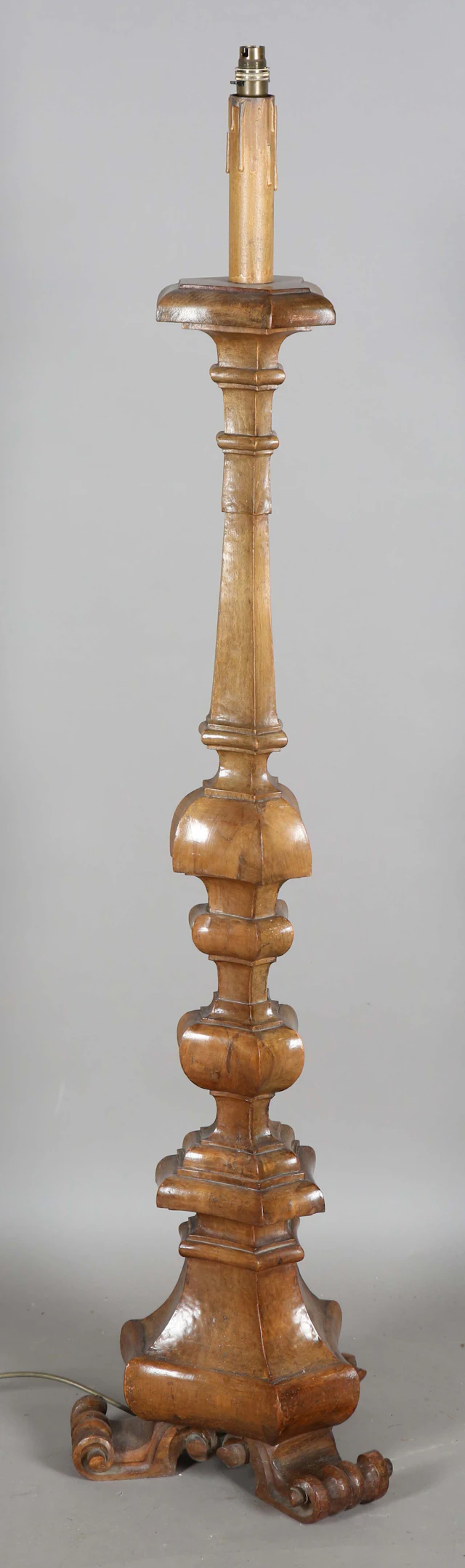 An early 20th century Continental carved walnut lamp standard of multiple