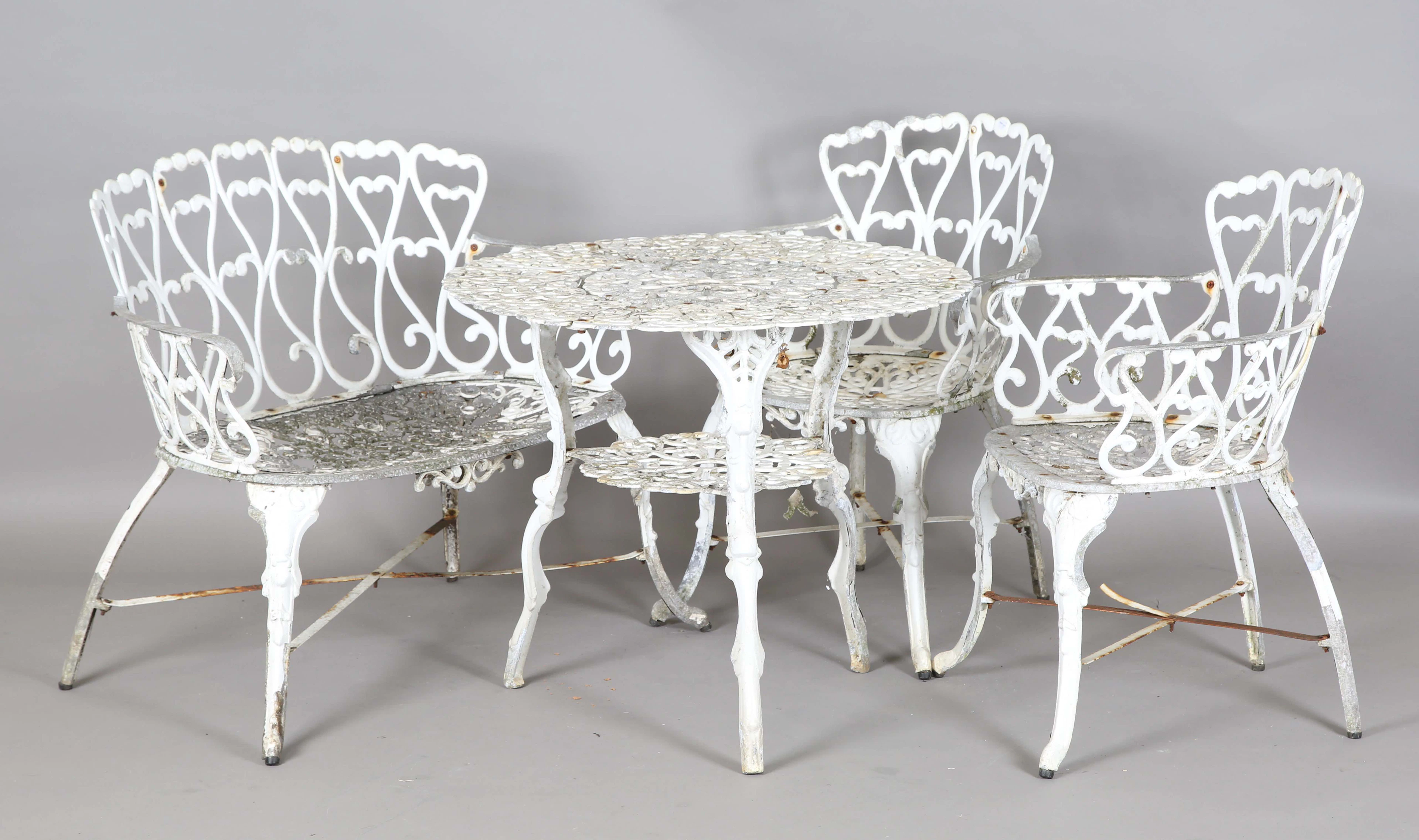 A 20th century white painted cast alloy garden suite, comprising a