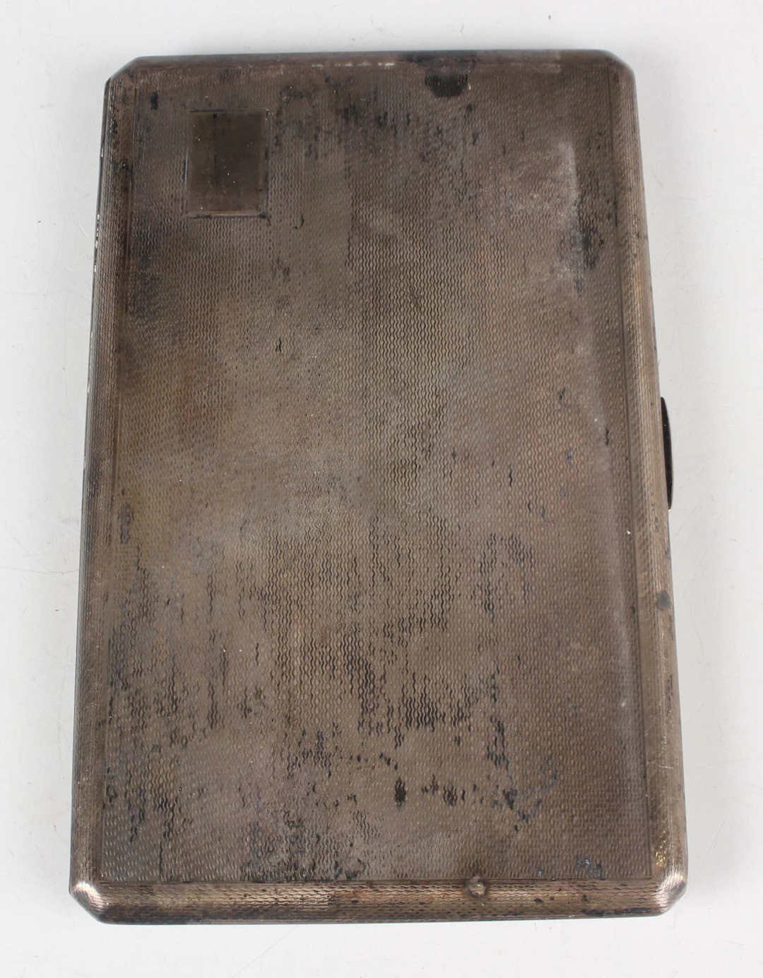 An Elizabeth II silver rectangular cigarette case with engine turned