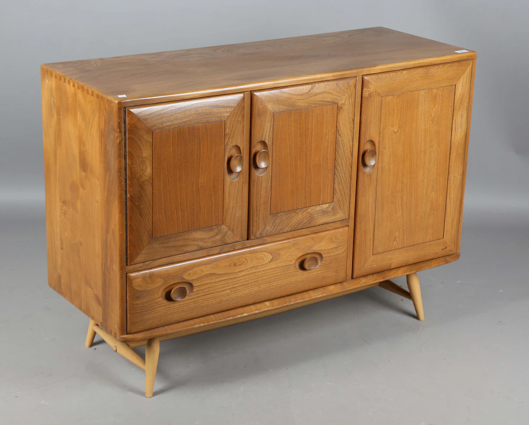 An Ercol elm sideboard, fitted with three doors and a single drawer