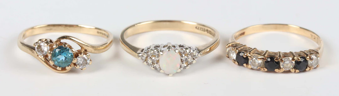 A 9ct gold, opal and diamond ring, claw set with the oval opal between