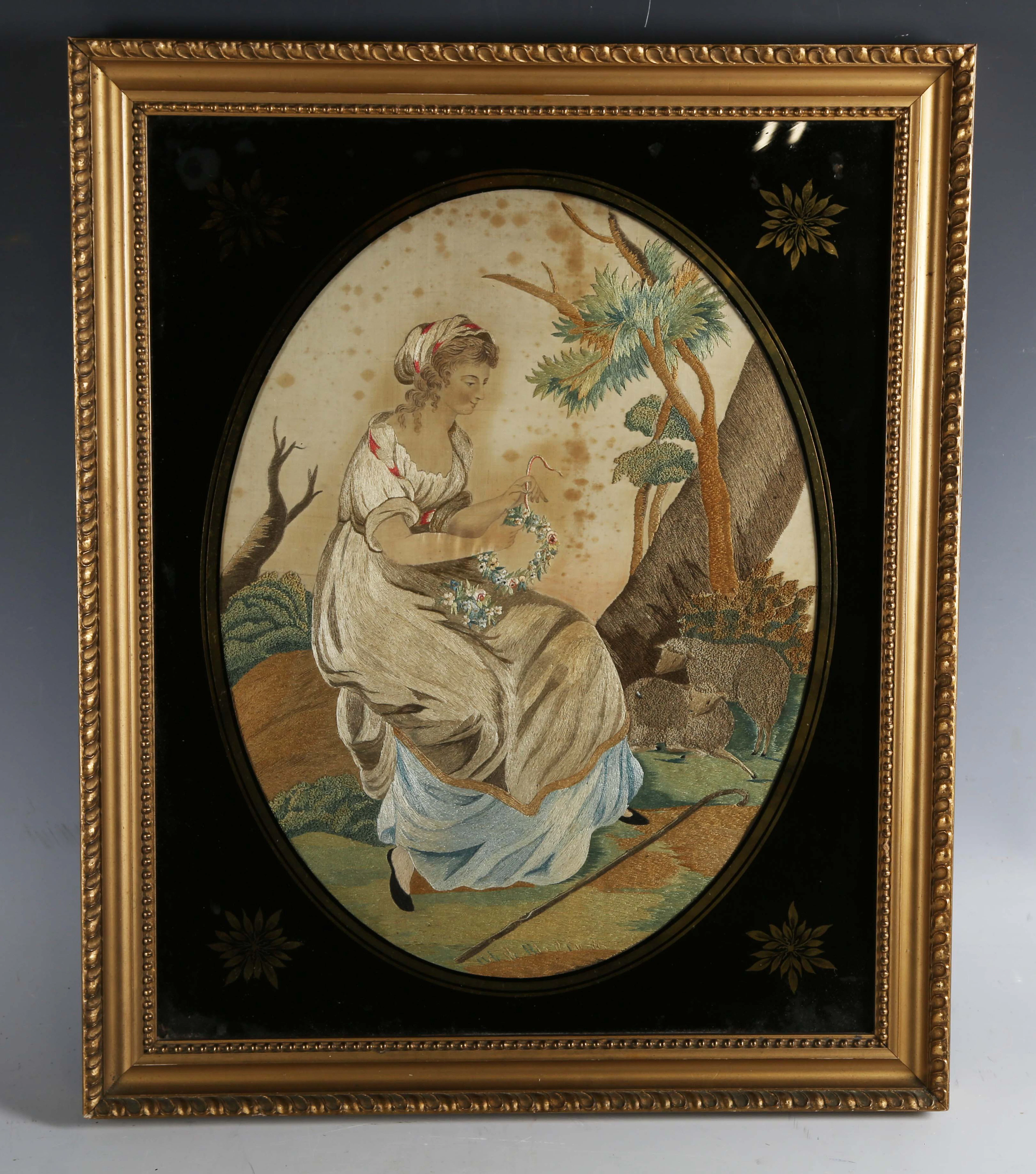 A Regency style silkwork and chenille oval panel of a seated shepherdess
