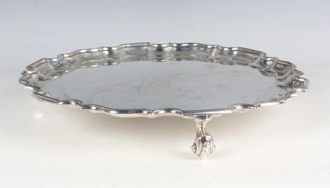 A George V silver salver of circular form with piecrust rim, raised