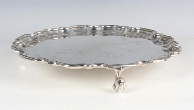 A George V silver salver of circular form with piecrust rim, raised