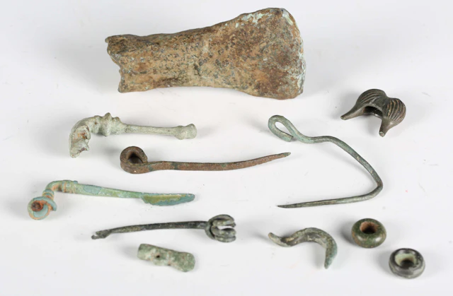 A group of Iron Age artefacts, including an axe head, three copper