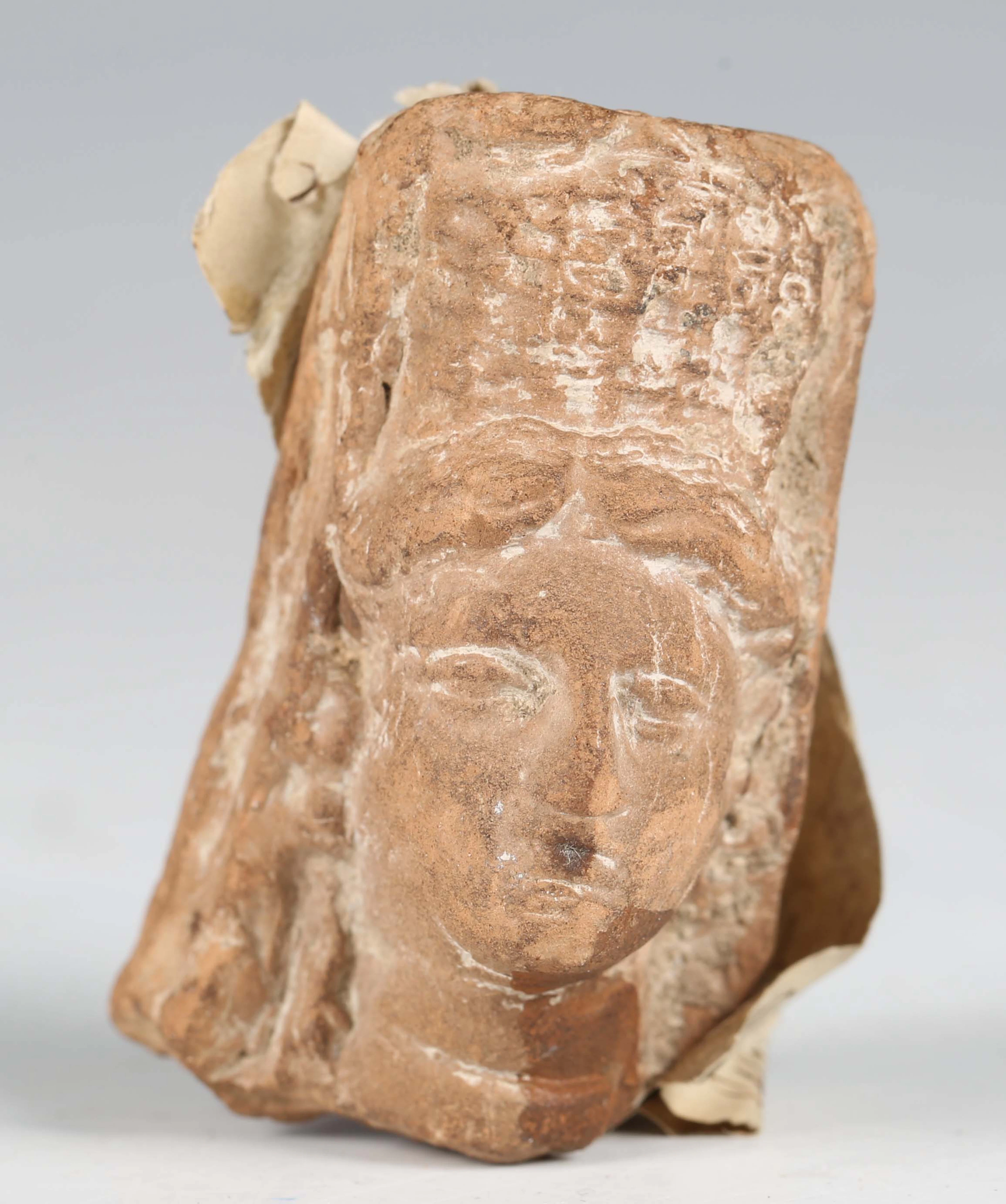 A Hellenistic ancient Greek terracotta head fragment, bearing hand-written