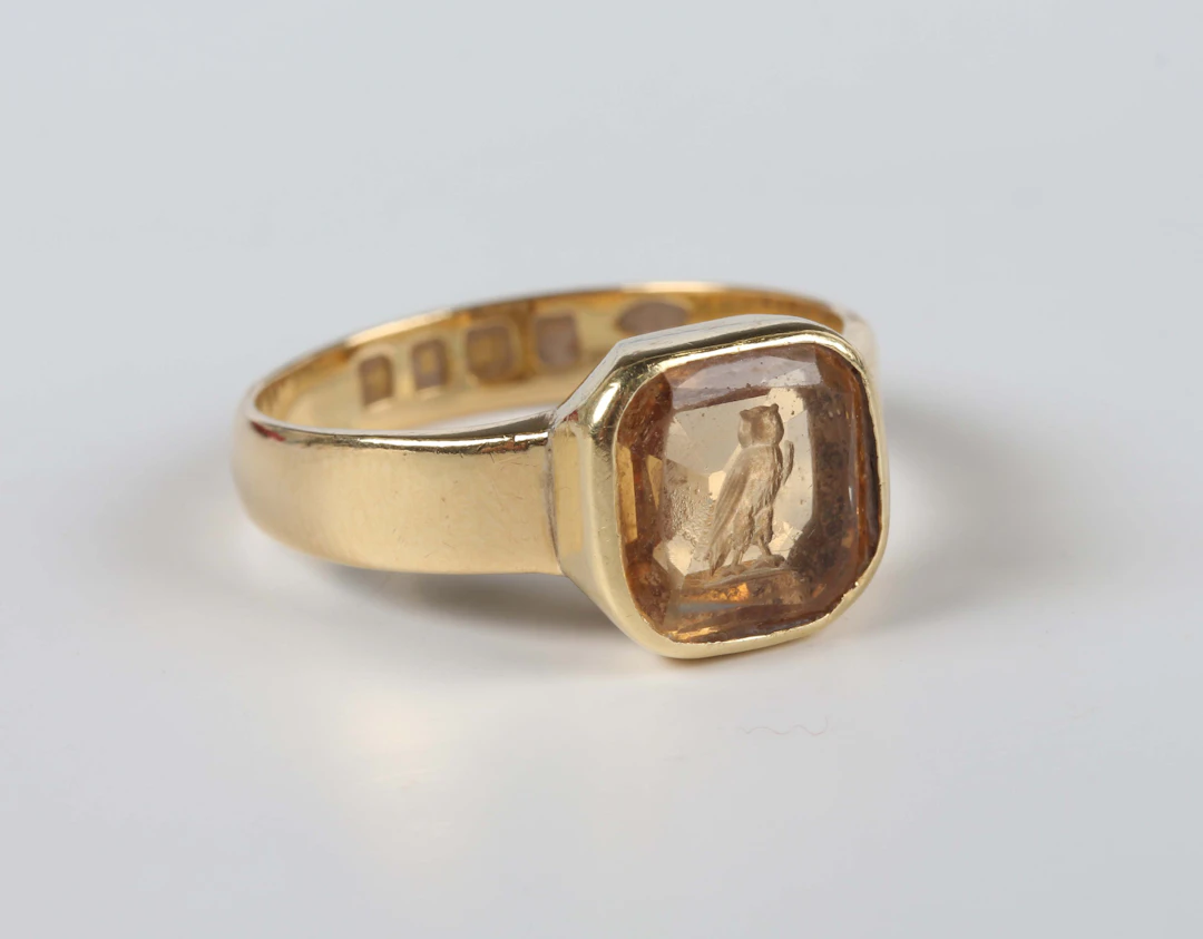 An 18ct gold and citrine intaglio ring, carved with an owl, London