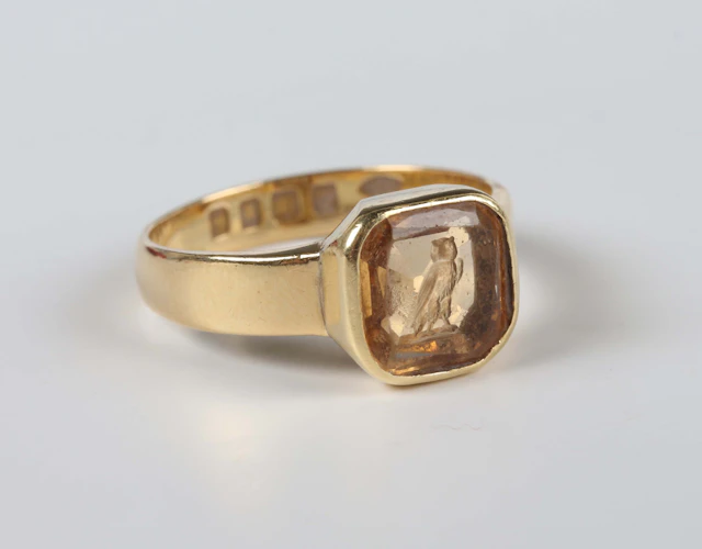 An 18ct gold and citrine intaglio ring, carved with an owl, London