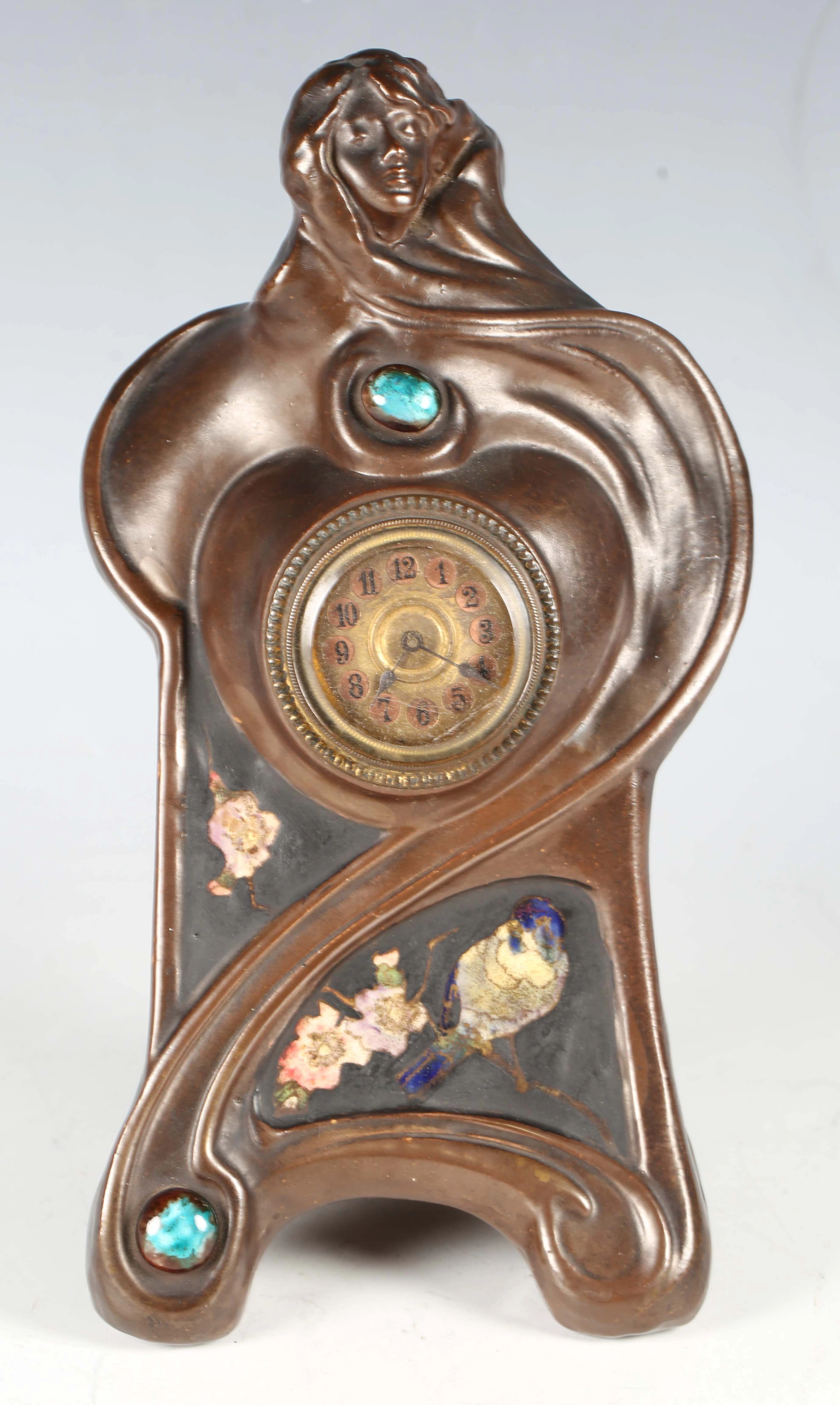 An Art Nouveau Bretby pottery mantel clock, the bronzed body with