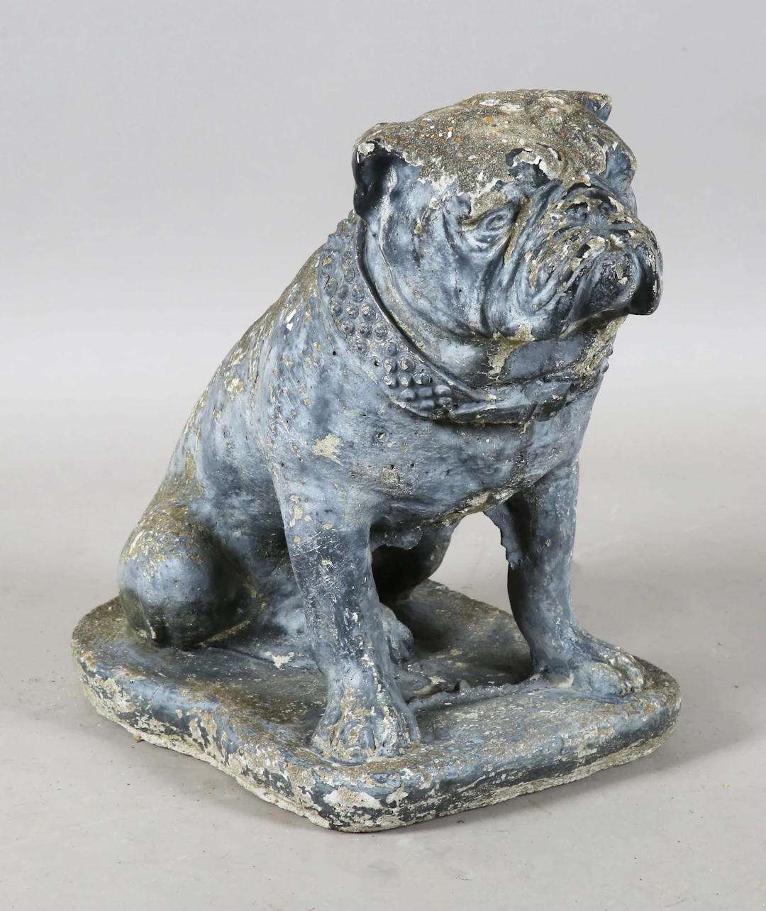 A 20th century cast composition stone garden model of a seated bulldog