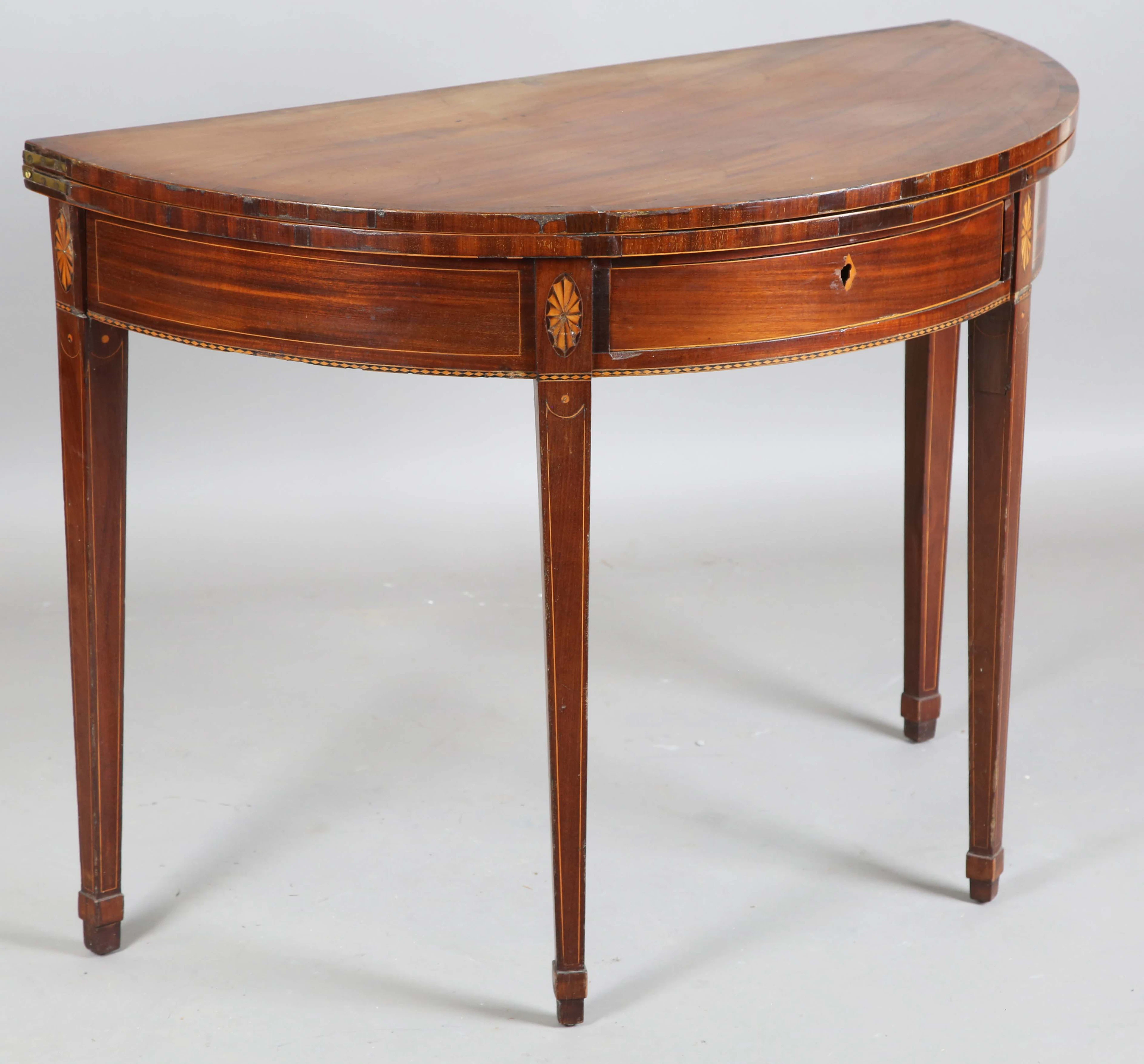 A George III mahogany demi-lune fold-over tea table with inlaid borders