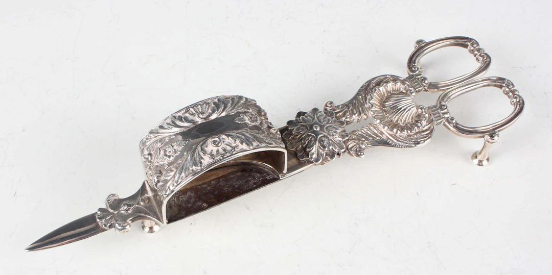 A pair of George IV silver candle snuffers with scallop shell and