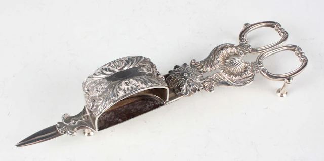 A pair of George IV silver candle snuffers with scallop shell and