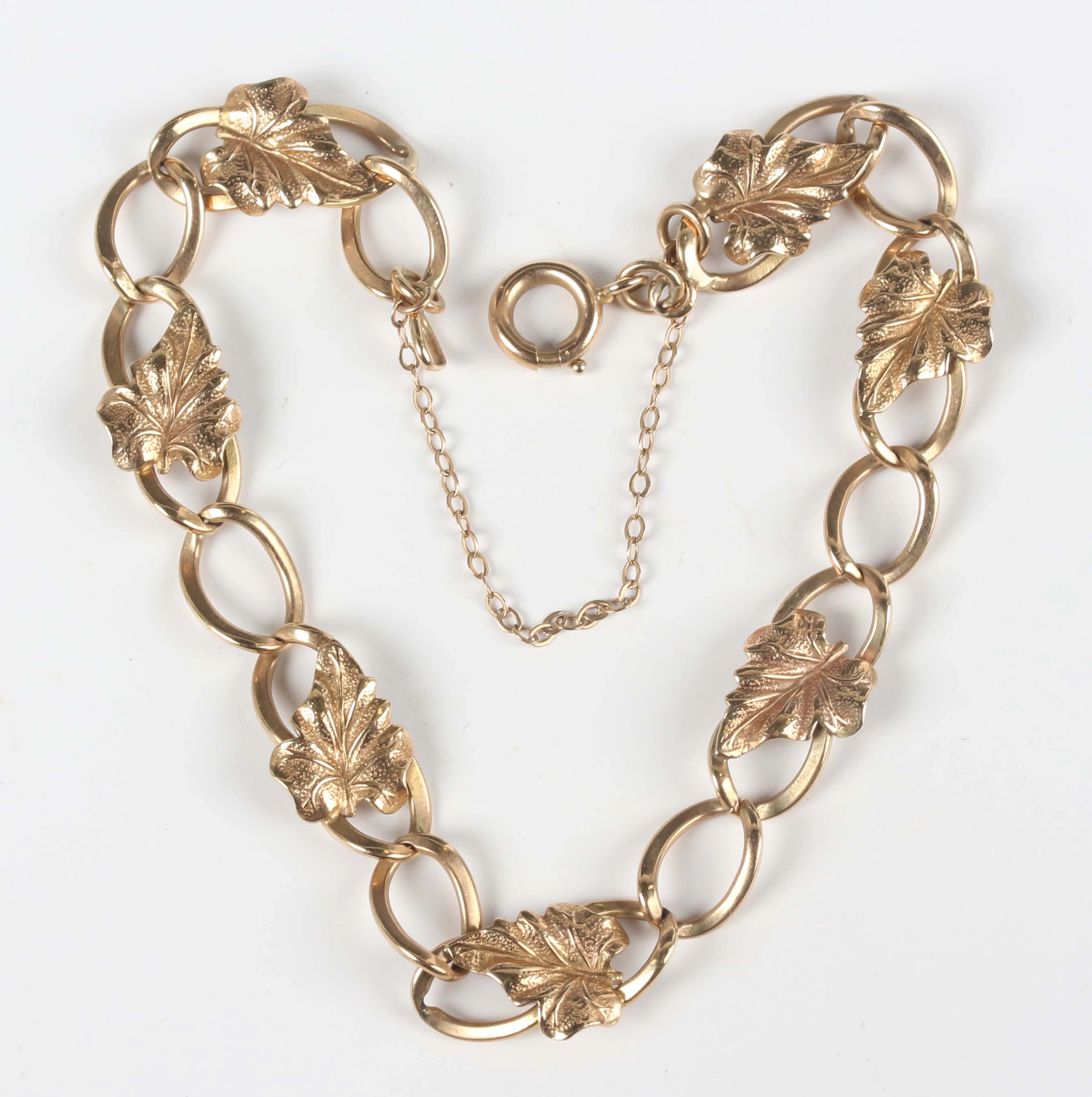 A 9ct gold curblink bracelet, applied with leaf motifs at intervals