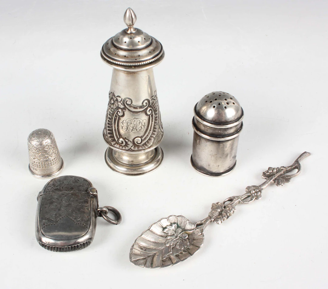 A late Victorian silver pepper caster of conical form with embossed