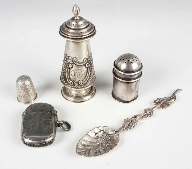 A late Victorian silver pepper caster of conical form with embossed