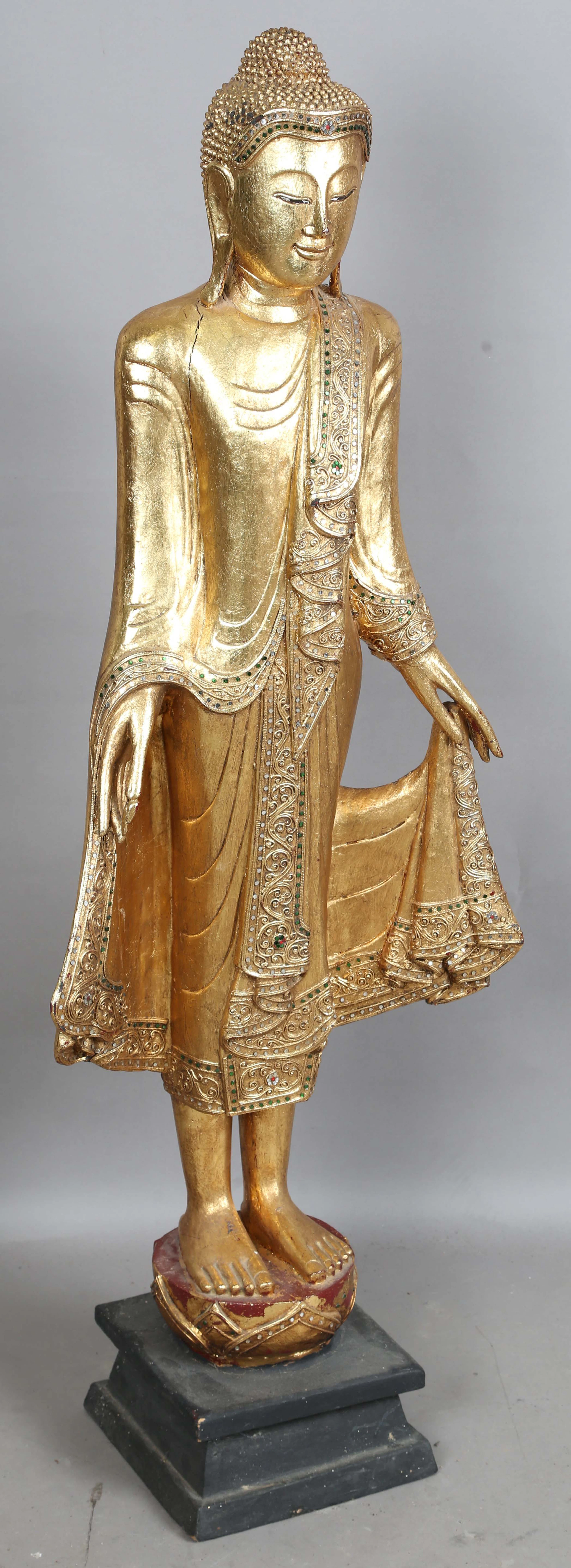 A large South-east Asian carved giltwood standing Buddha, height 130cm