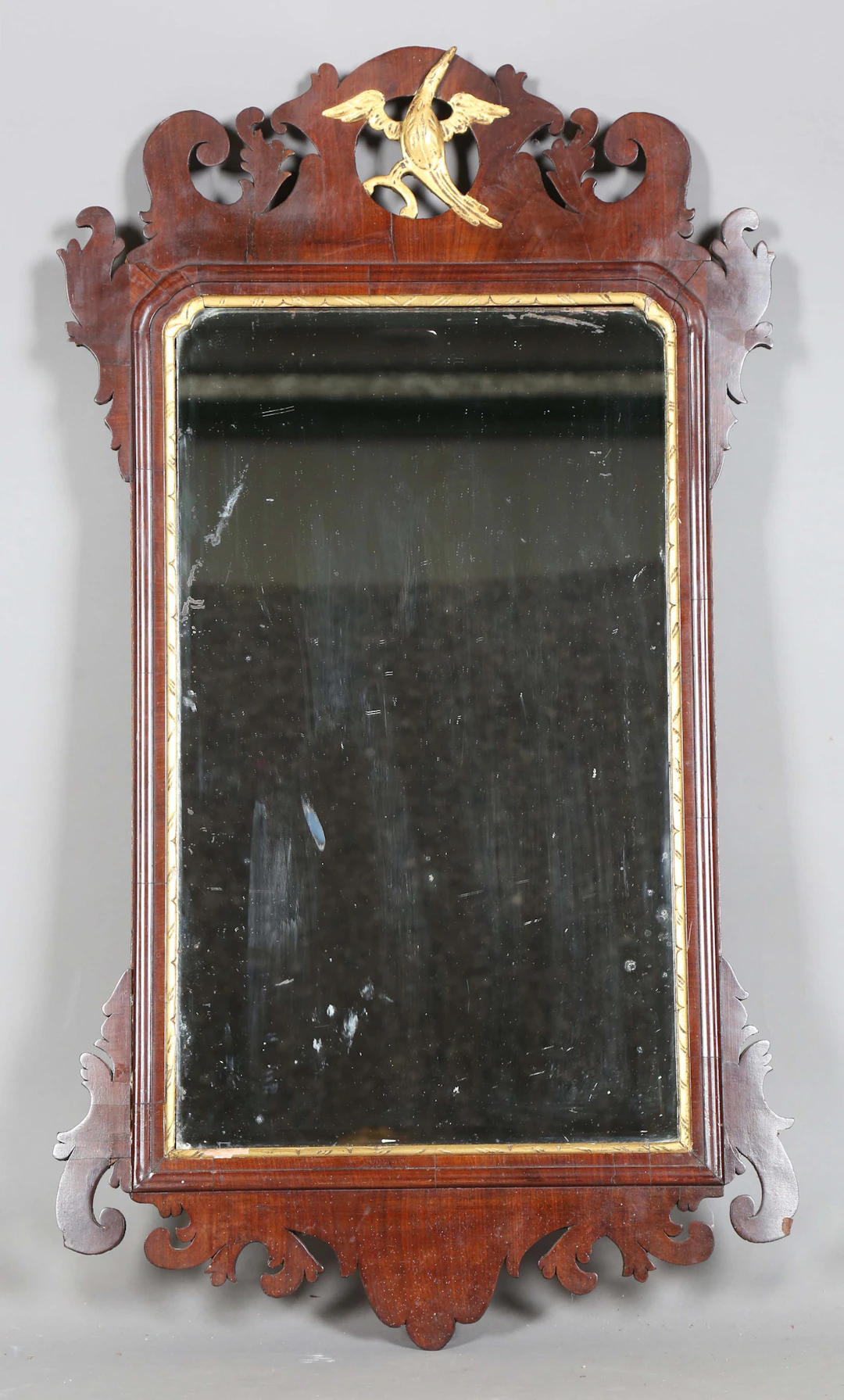 A George III walnut fretwork wall mirror with a pierced and carved