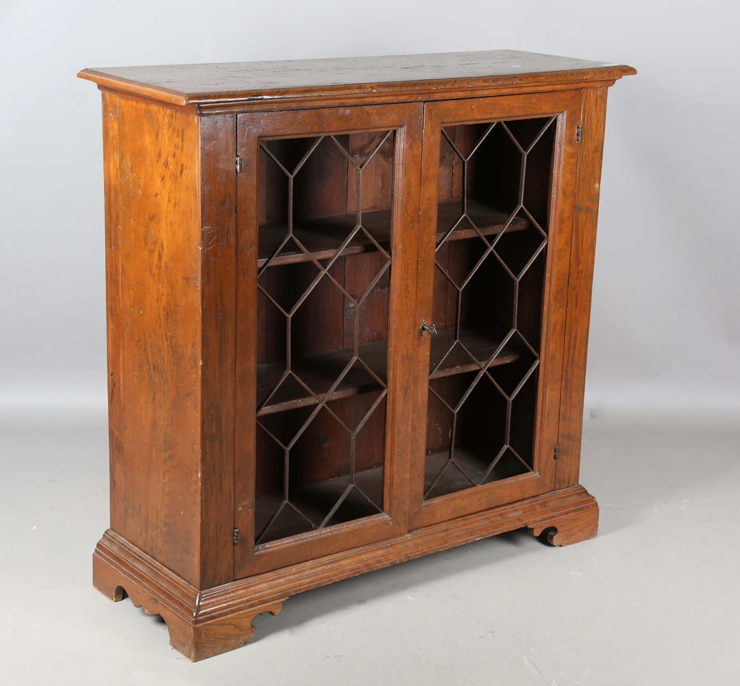 A 20th century provincial elm two-door bookcase, the doors inset with
