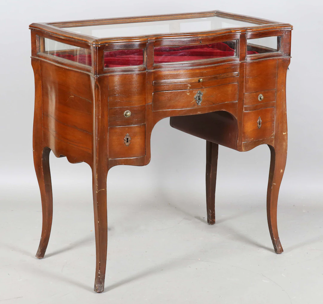 An early 20th century walnut bijouterie table, the glazed top above